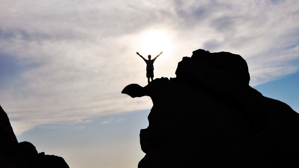 die-silhouette-einer-person-auf-einem-felsen