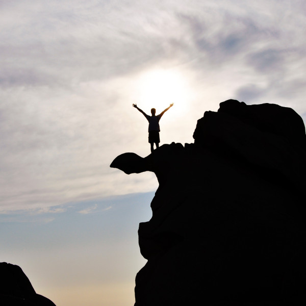 die-silhouette-einer-person-auf-einem-felsen