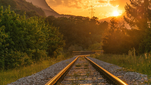 Bahnschienen-und-ein-Sonnenuntergang-im-Hintergrund