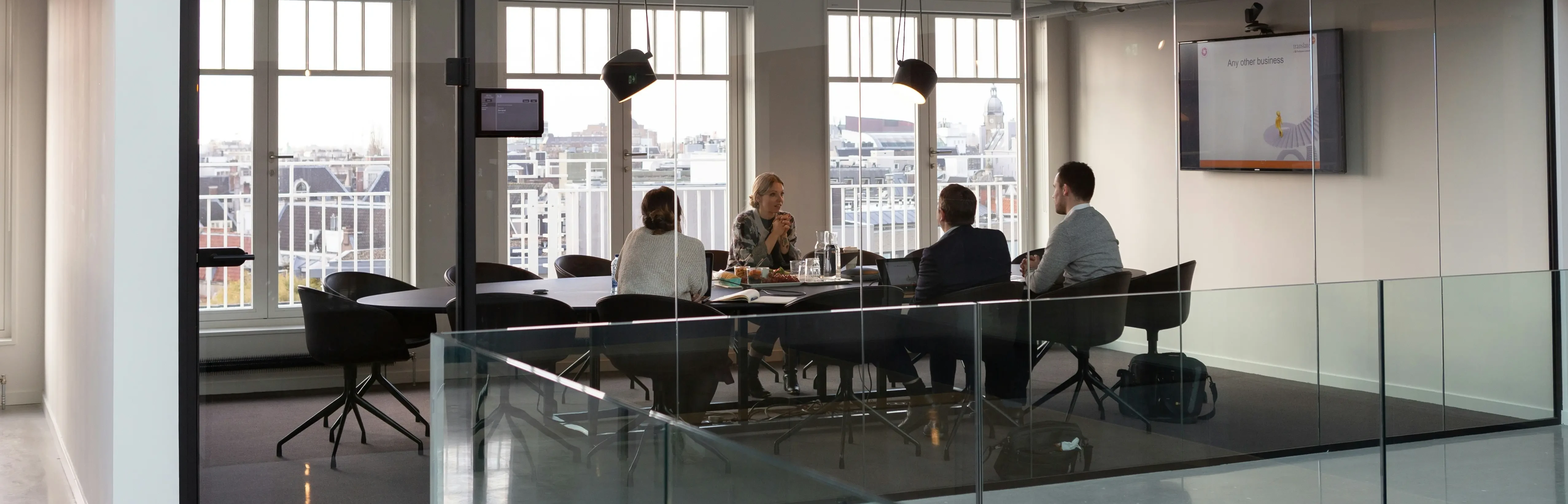 Eine Gruppe von Menschen sitzt an einem Tisch und diskutiert über Systemanforderungen