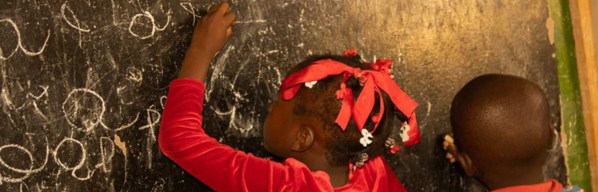 Mädchen schreibt an Tafel - Referenz Kindernothilfe