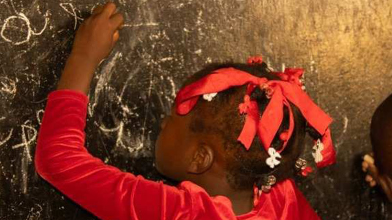 Mädchen schreibt an Tafel - Referenz Kindernothilfe